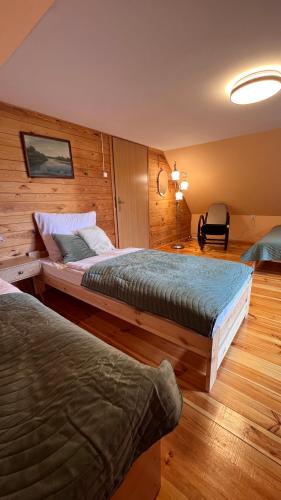 a hotel room with two beds and a chair at Leonówka in Nowogród