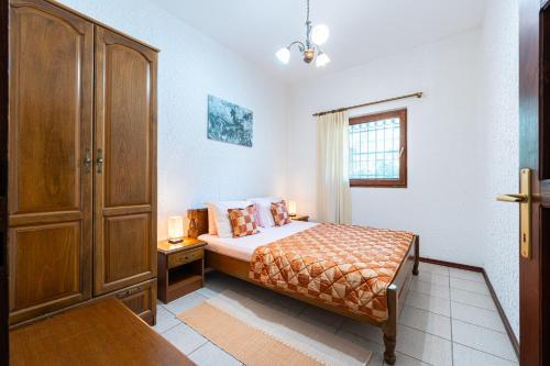 a bedroom with a bed and a wooden cabinet at Hotel Dubrava in Budva