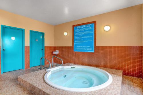 a large bath tub in a bathroom with blue doors at Prairie Crest Red Deer by IHG in Red Deer