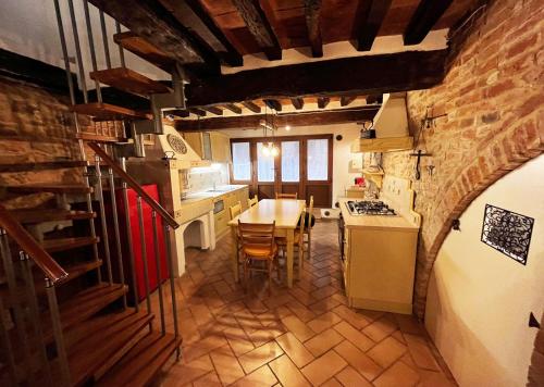 a kitchen with a table and a stove top oven at Dimora del Campanile in Torrita di Siena