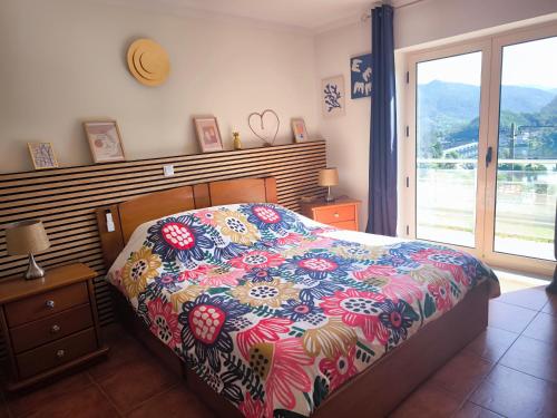 a bedroom with a bed with a colorful comforter at CASA CAPUCINE in Rio Caldo