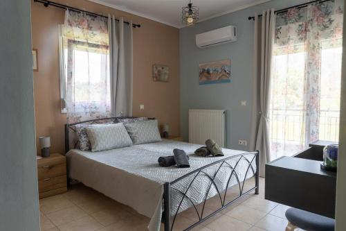 a bedroom with a bed with two shoes on it at Lanari Valley House 2 in Thermi