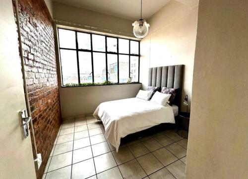 a bedroom with a white bed and a window at Tulisa Park in Johannesburg