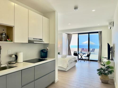 a kitchen and living room with a view of the ocean at Little Pearl Sea View Studio in San Antonio del Mar