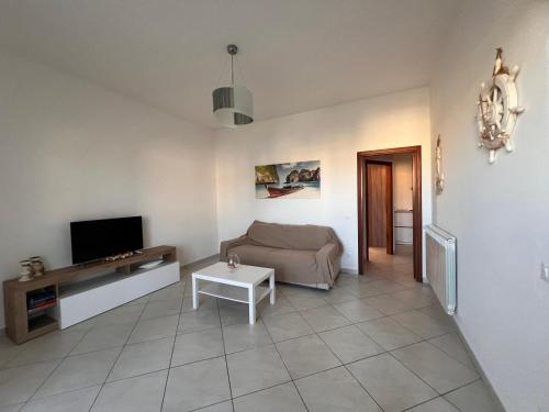 a living room with a couch and a tv at Casa sole cuore amore in Torre del Lago Puccini