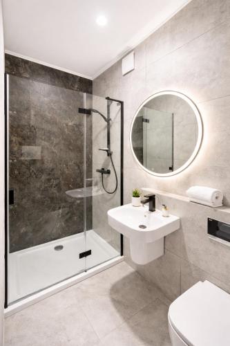 a bathroom with a shower and a toilet and a sink at Villa Malibu in Zegrze Południowe