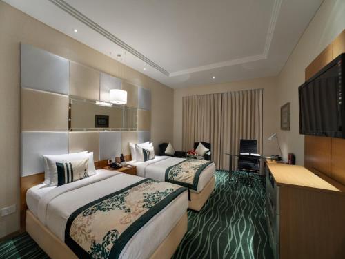 a hotel room with two beds and a television at Orange Megastructure LLP in Surat