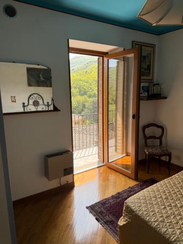 a bedroom with a door open to a balcony at La casa dei Nonni in Romagnese