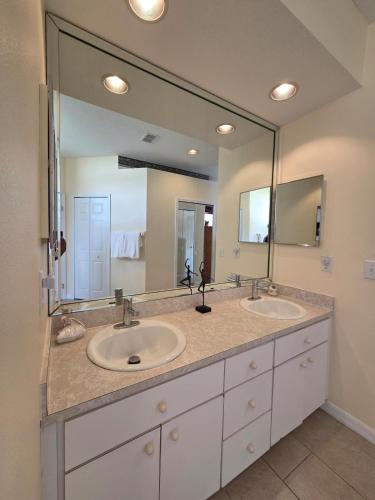 a bathroom with two sinks and a large mirror at Accessible-Friendly Pool Retreat Extended Stay Welcome in Valrico