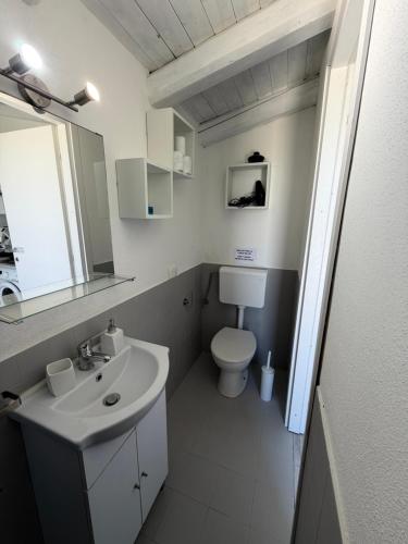 a white bathroom with a sink and a toilet at Green House La Torre in Avola