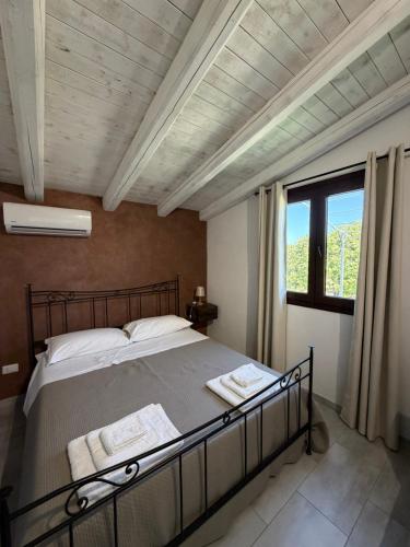 a bedroom with a bed and a large window at Green House La Torre in Avola