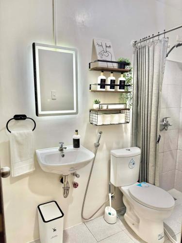 a bathroom with a toilet and a sink at Entire House with Parking, Full Kitchen and Near SRP, Seaside and Nustar in Talisay