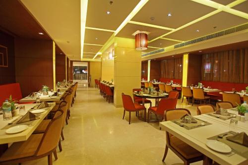 a dining room with tables and chairs in a restaurant at Comfort Inn Legacy in Rajkot