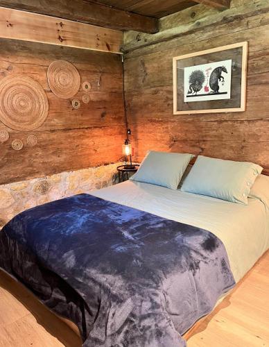 a bed in a room with a wooden wall at Cabañas La Tierra Grande in Zacatlán