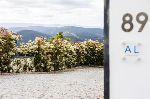 a clock with the number on it next to flowers at Casa Alto da Massada in Canelas