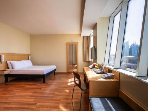 a hotel room with a bed and a desk at Ibis Riyadh Hotel Al Muhammadiyah United Company Branch in Riyadh