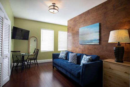 a living room with a blue couch and a table at Duval Street Suite w kitchen and shared heated pool in Key West