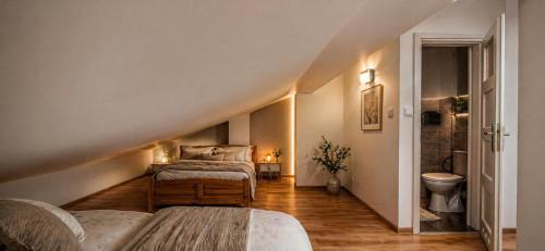 a attic bedroom with two beds and a bathroom at Mountain View Apartament Termy Chochołowskie 5 min in Suchá Hora