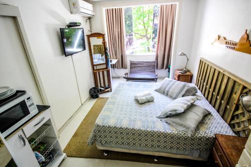 a bedroom with a bed with pillows on it at Baixo Copa Guest House in Rio de Janeiro