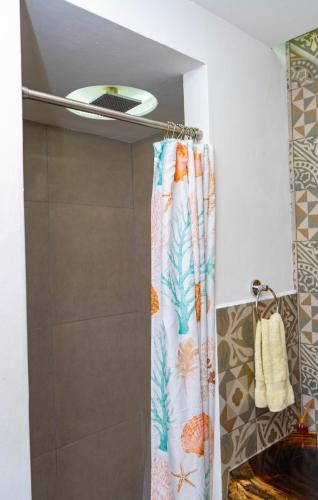 a shower with a shower curtain in a bathroom at Olas Permanentes El Zonte in El Zonte
