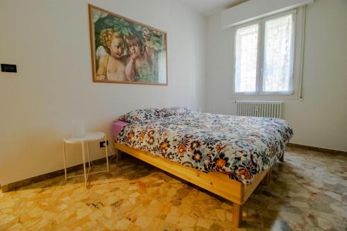 a bedroom with a bed and a painting on the wall at B&B Casalecchio Appartamento privato in Casalecchio di Reno