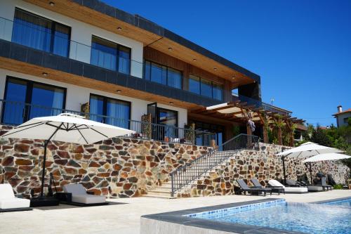 a hotel with umbrellas and chairs next to a pool at Quinta de Raj - Your Douro Valley Retreat in Peso da Régua