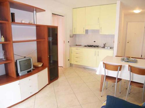 a kitchen with a table and a tv in it at Zancan Appartament in Grado