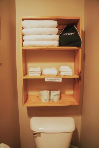 ein Badezimmer mit einem Regal mit Handtüchern und einer Toilette in der Unterkunft Lenroot Lodge in Seeley