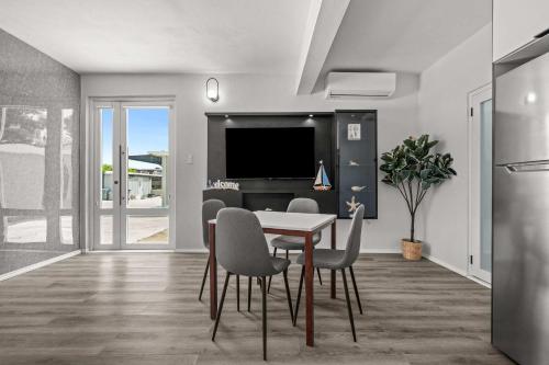 a dining room with a table and chairs and a television at Balandras Beach Stay 1 Beach & Pool Access in Dorado
