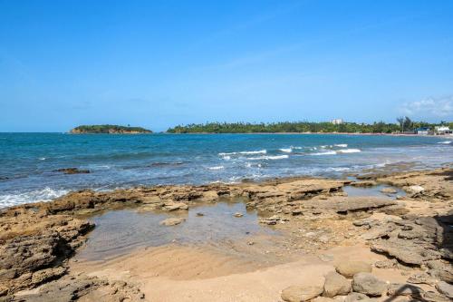 a beach with rocks and the water and trees at Balandras Beach Stay 3 Beach & Pool Access in Dorado