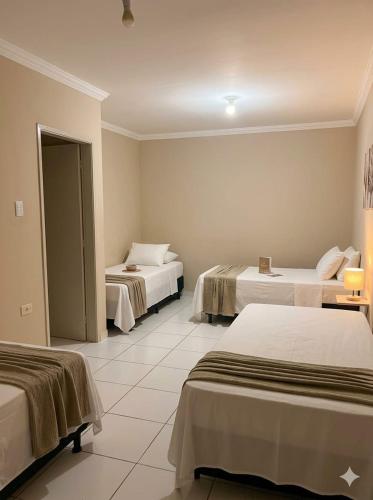a hotel room with two beds in a room at Kairos Pousada e Hostel in Cabo de Santo Agostinho