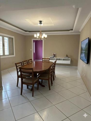 a dining room with a wooden table and chairs at Kairos Pousada e Hostel in Cabo de Santo Agostinho