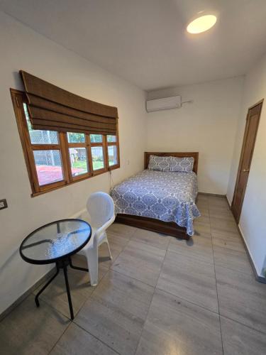 a bedroom with a bed and a table and a chair at Harvestmoon Boutique Hotel in Las Piedras