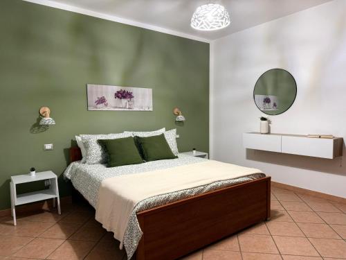 a bedroom with a bed with green walls and a mirror at Casa Rina in Piano Conte