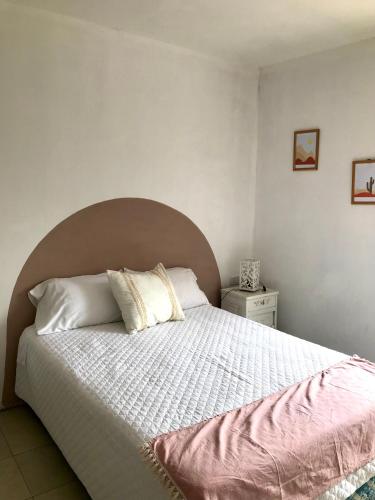 a bedroom with a large bed with white sheets and pillows at Hospedaje Las Moreras-Vaqueros in Vaqueros