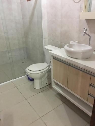 Un baño con inodoro, lavabo y ducha. en Apto 103 Maria Helena, en Torres