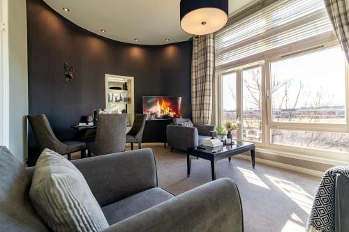 a living room with a couch and chairs and a fireplace at Stirling Riverview Apartment - Free Parking in Stirling