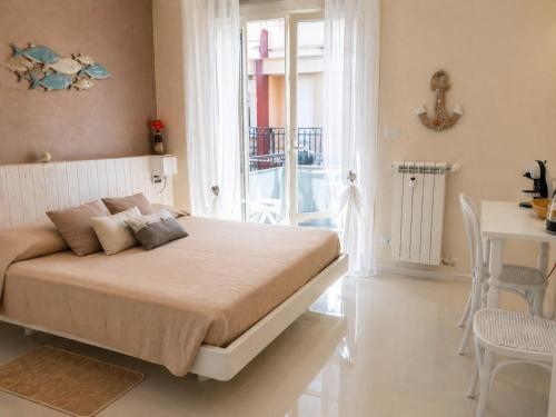 a bedroom with a bed and a table and chairs at Blu Marina Alassio in Alassio