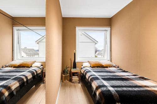 two beds in a room with two windows at Casa Formentera in Molde