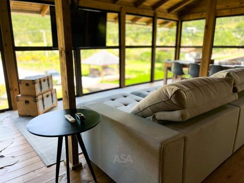 a living room with a couch and a table at Luxury Chalet Retreat with Jacuzzi & Fireplace in Itajaí