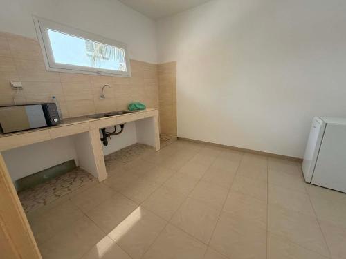 a small kitchen with a sink and a microwave at Anta's House Sipres - Chambre calme et confortable in Dakar