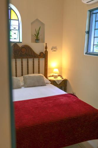 a bedroom with a large bed with a red blanket at Hostel Castell Di Madre in Santos