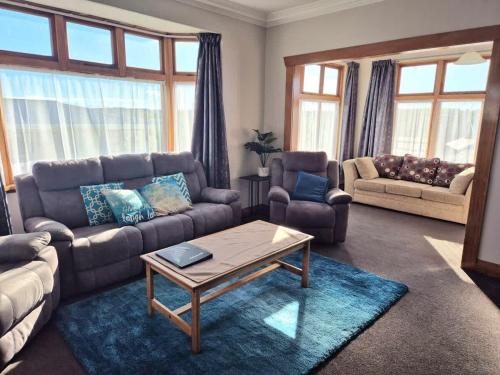 a living room with a couch and a coffee table at Cosy On Till in Oamaru