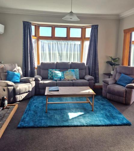 a living room with a couch and a coffee table at Cosy On Till in Oamaru