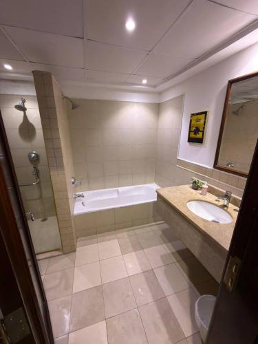 a bathroom with a tub and a sink and a bath tub at شاطئ المرجان in King Abdullah Economic City