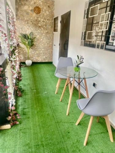 a room with a green floor with two chairs and a table at CHAMBREs SALON MEUBLÉ HD in Yamoussoukro
