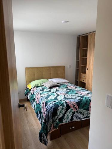 a bedroom with a bed with a quilt on it at Boreal House in Manizales
