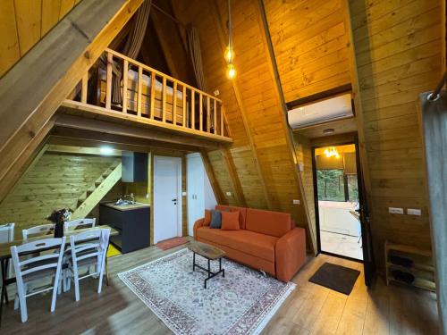 a living room with a staircase and a couch and a table at Alpine Cabins Gjinar in Gjinar