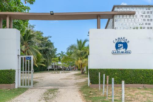 a gate in front of a building with palm trees at Cabañas La Fragata Coveñas in Coveñas