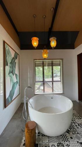 a large white tub in a bathroom with a window at Sepilok Nature Lodge - Formerly known as Sepilok Nature Resort in Sandakan